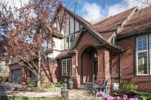 The brick archway entry of this classic Tudor style Charles Cudd home is a grand welcome for your arriving guests.