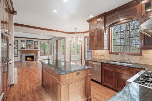 The kitchen opens into the sunroom and the fireplace gathering area. The open layout makes for easy flow, allowing guests to mingle in the kitchen or carry their drinks into the connected rooms.