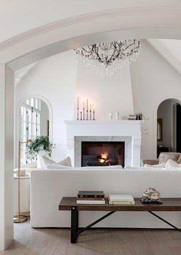 The great room features a soaring 18 -foot vaulted ceiling. A floor to ceiling natural stone gas fireplace surround and gorgeous oversized chandelier.