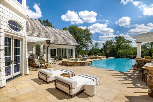 The stone deck offers expansive space for furniture placement. The spa off the pool is ideal for that jacuzzi experience.