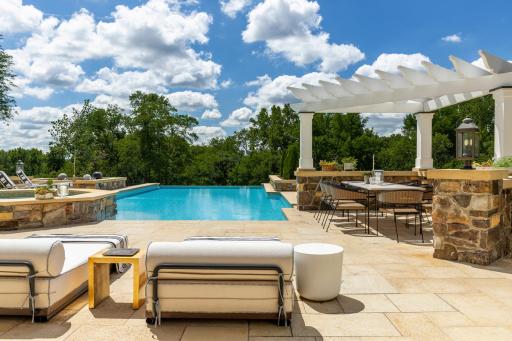 Welcome to your outdoor multi-level limestone pool deck with a saltwater infinity pool.