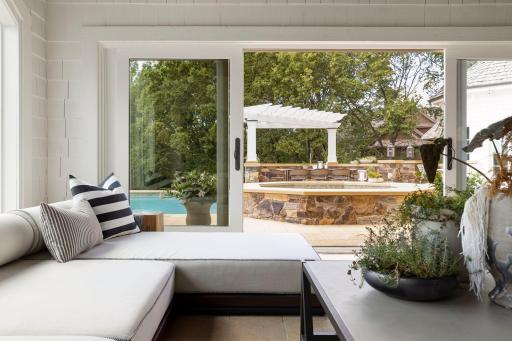This attached sunroom is used year round and functions as a perfect pool house in the summer. The Doors open the room entirely to the outdoors.