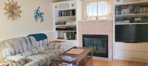 Family room is off the kitchen area. Built-in surround the gas fireplace and two speakers are included/
