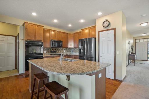 Kitchen complete with double ovens, breakfast bar plus eat in kitchen area, easy access from garage and view of front entry.