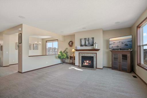 Creative architecture showcases a formal dining room and family room with cozy gas fireplace.
