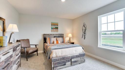 One of three, large, secondary bedrooms. *Photo is of a model home, colors may vary in actual home.