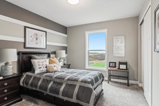 (*Photo of decorated model, actual homes colors and finishes will vary) One of three generously sized secondary bedrooms with a spacious closet!