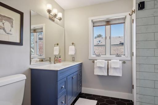 Newly renovated primary bedroom en suite bathroom with walk-in shower, hex tile, and glass shower door. Must see in-person.