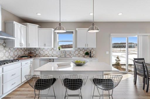 (Photo is of a model, homes finishes will vary) This spacious kitchen features a large center island, quartz countertops, LVP floors, stainless appliances and more.