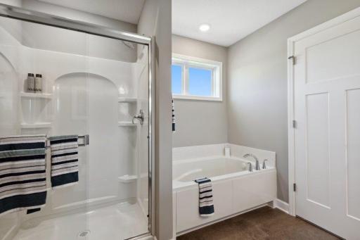 (Photo is of a model, homes finishes will vary) Model Photo: An extension of the primary bedroom, this spacious bath includes a double-vanity, a soaking tub and a separate shower.