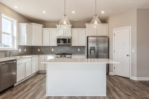 (Photo of an inventory home, actual homes finishes will vary) The actual kitchen will be Gourmet. This spacious kitchen features a large pantry, quartz countertops, LVP floors, stainless appliances and more!