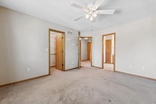 Another view of the primary bedroom showing the walk in closet and walk through to the full bath.