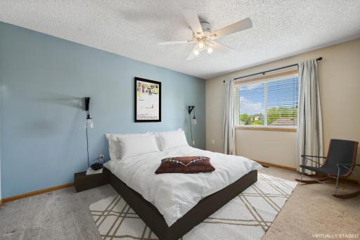 The primary bedroom on the upper level includes a ceiling fan, walk in closet (not pictured), and a walk through to the full bathroom
