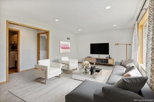 The living room has new carpeting, recessed lighting and overlooks the backyard.