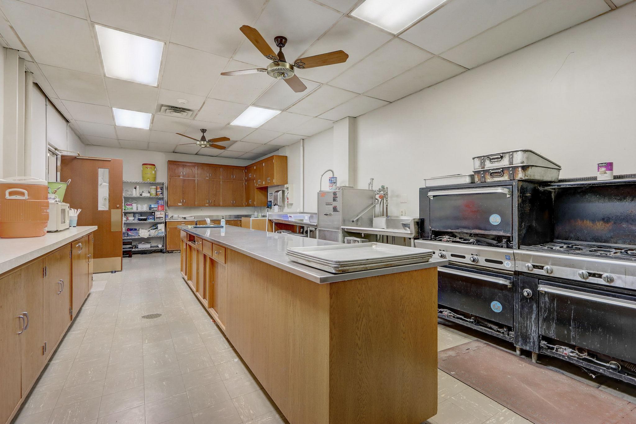 Alternate view of the kitchen with commercial dishwasher, and 2 ranges.