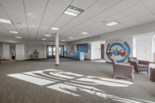 The welcoming lobby provides ample gathering space. Features include children's ministry check in area, adjacent cafe, access to the worship center and offices, and large windows bringing in plenty of light.