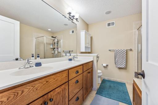 Primary bathroom features double vanity, separate tub and shower