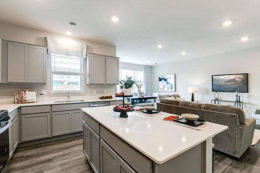 A window above the sink, lots of cabinets, designer quartz, a spacious center island, and gas range, a dream kitchen for sure! *Photo is of model home, colors and selections shown may vary.
