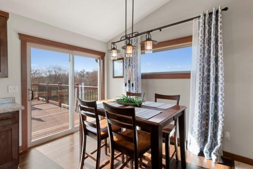 Informal dining room features stylish lighting, beautiful laminate floors and access to the backyard deck.