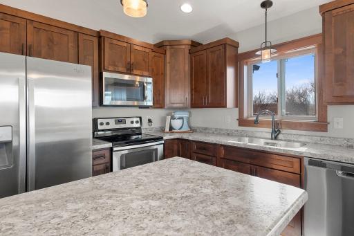 Kitchen upgraded with stainless steel appliances, soft close cabinetry, and stylish pendant lighting.