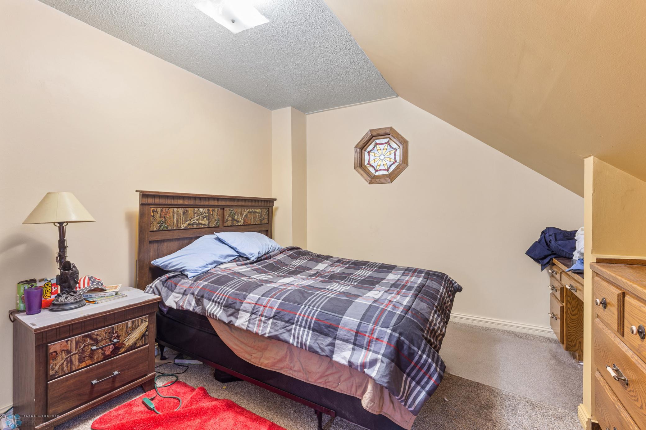 Bedroom 2 (upstairs) with built in desk and dressers, a closet and stained glass window.
