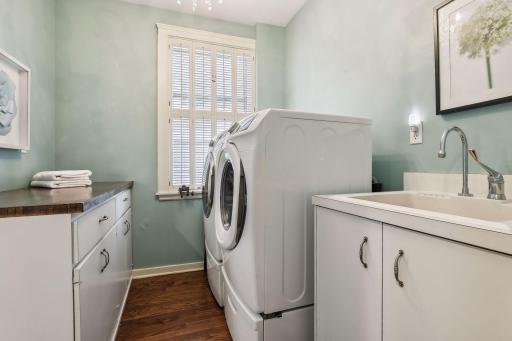 The new main level laundry room offers storage, custom cabinetry and a sink.