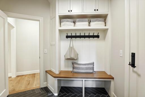 The mud room features a built-in bench with everyday coat/shoe storage, as well as a walk-in closet with built-in organizers