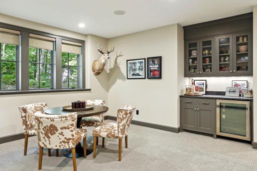 A built-in bar with beverage fridge and game table space are offered in addition to the media area.