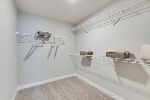 Massive walk-in closet alert! May need to go clothes shopping after moving into this home! Staged model photograph, some options and colors may vary.