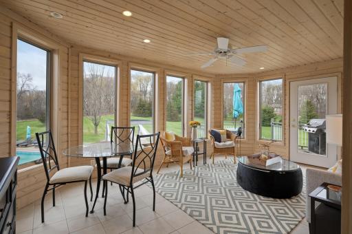 An impressive three-season porch finished in elegant tongue & groove, wall to wall windows with views of your private acreage, magnificent pool area, and a private deck.