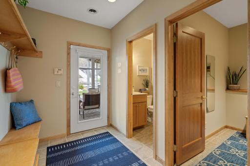 Pool mudroom with three-quarter bathroom, dressing room, built-in bench and hooks, and a screened-in patio with access to the backyard!