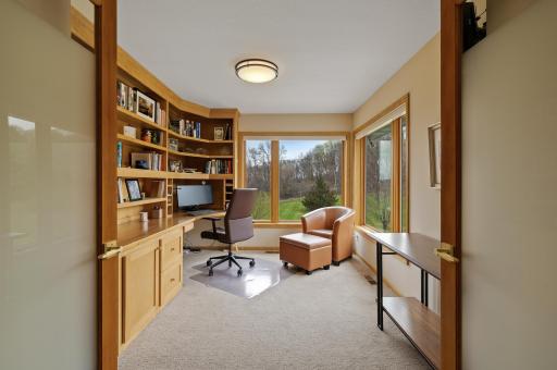 Upper level bedroom or office with built-in desk and shelves.