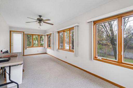 Large sunroom behind garage with access to outside from the side door and steps