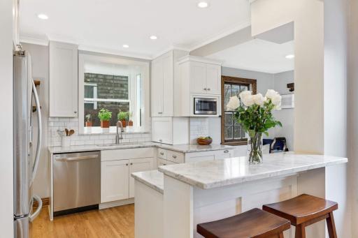 Kitchen features custom cabinetry throughout, as well as marble countertops and stainless steel appliances. Countertop seating offers space for informal dining.