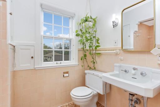 Charming primary bathroom features beautiful tile and charming vintage style fixtures.