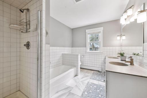 Perfect hall bathroom with dual-sink vanity, separate tub and shower, and custom tilework.