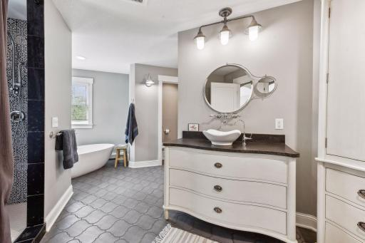 The primary bathroom is spacious and bright, with a free-standing soaker tub, spa-like shower with custom tile work, and two separated vanities so everyone can get ready at the same time without getting in each other's way.