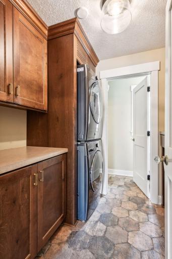 Don't miss the extras in this laundry room-- there's a pull out drying rack, built in hamper, and tons of cabinetry. There's also a powder bathroom (just past the doorway shown here).
