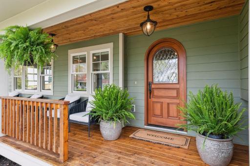 Freshly stained deck, paneled ceiling, and custom front door adds appeal to your approach.