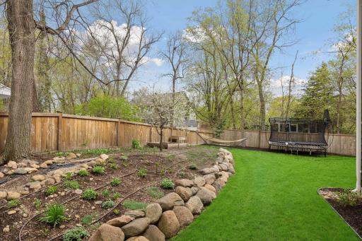 Full privacy fencing surrounds the yard, and the perimeter is lined with perennial gardens. Full irrigation system was new in 2023