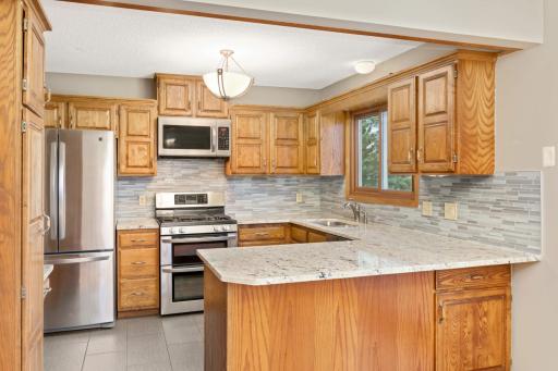 Kitchen with granite tops and glass backsplash