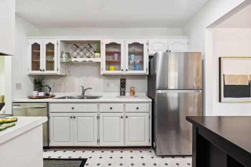 Galley kitchen with white cabinetry and stainless-steel appliances.