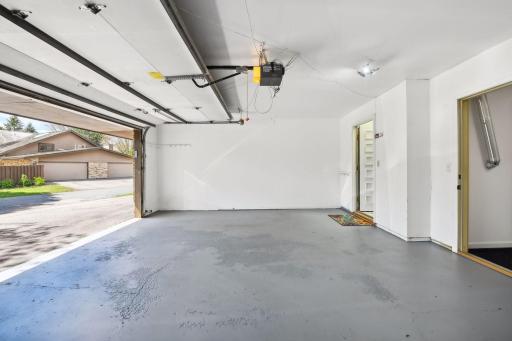 Spacious attached garage with additional storage room.