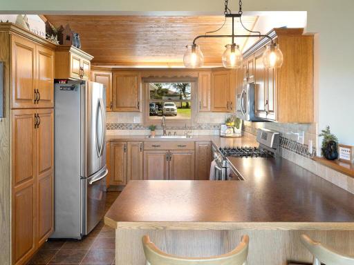 Breakfast bar is fun for casual breakfasts, snacking, and letting everyone socialize. Lighting throughout the home has been replaced and updated. Don't miss the large kitchen over-the -sink window!