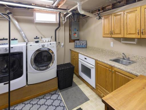 Lower level laundry room doubles as a spare baking area with an extra oven, sink, and counter space.