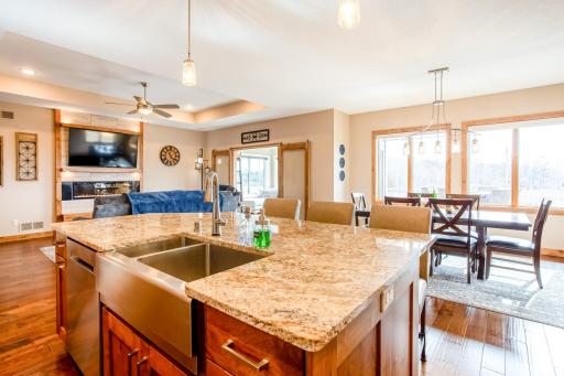 Gourmet eat-in kitchen with an oversized farmhouse sink, stainless appliances, Alder woodwork, dual wall ovens, granite countertops, a walk-in pantry and a luxurious gas cooktop.