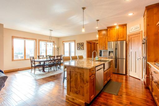 Gourmet eat-in kitchen with an oversized farmhouse sink, stainless appliances, Alder woodwork, dual wall ovens, granite countertops, a walk-in pantry and a luxurious gas cooktop.