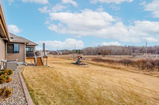Spacious lot with maintenance-free deck, a covered patio, a playground, and spectacular panoramic views of the wetland out back.