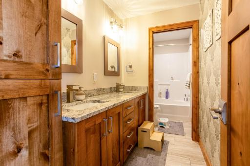 Full lower-level bathroom with dual sink vanity.