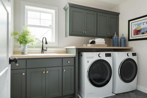 Ample Storage Space in the Laundry Room Complete with a Laundry Tub and Laminate Top